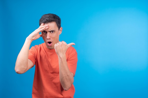 Astounded male touching forehead and pointing away