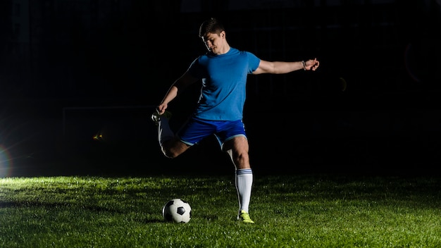 Athlete kicking soccer ball