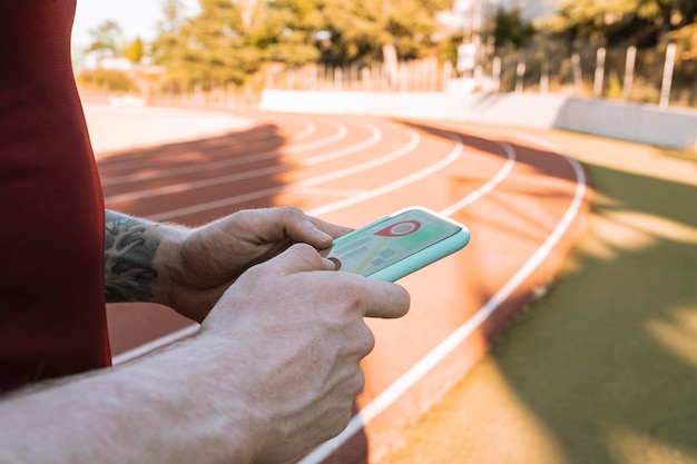 Athlete man hand with app on mobile phone