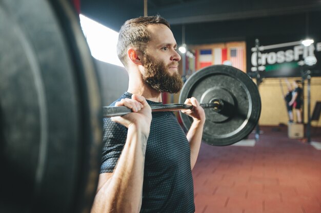 Athlete man with a beard exercising in a gym