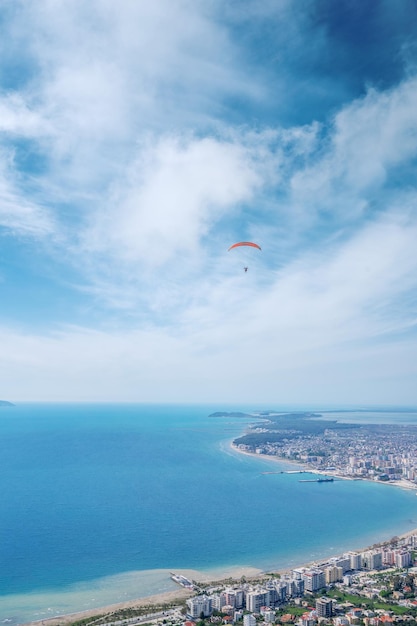 Athlete paragliding against the backdrop of a cloudy sky over the city on a summer day albania