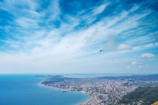 Athlete paragliding against the backdrop of a cloudy sky over the city on a summer day albania