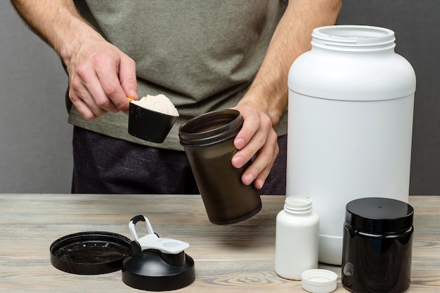 The athlete pours protein into a shaker The concept of sports nutrition