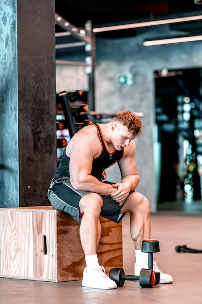 Athlete resting in the gym between exercises