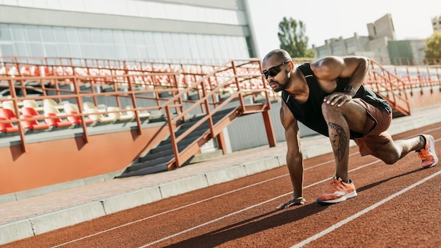 Athlete runner doing stretching exercises on the running track