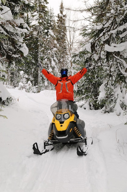 Athlete on a snowmobile moving in the winter forest in the mountains of the Southern Urals.