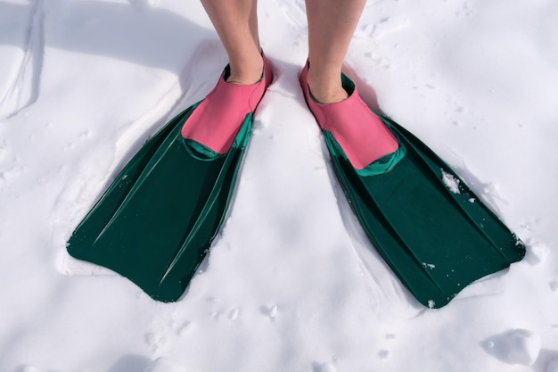 An athlete in swimming fins stands on the snow To mix up the ti