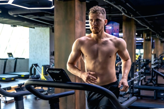 Athlete on a treadmill in the gym shirtless man in the gym sports lifestyle