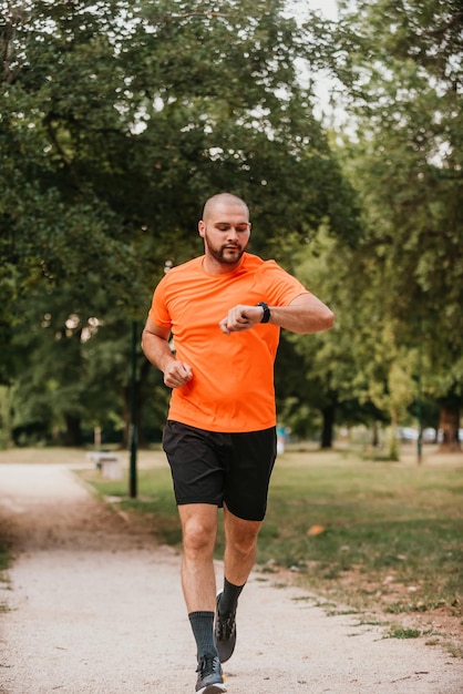 Athlete using a smartwatch while running in nature Healthy lifestyle