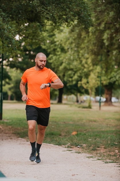 Athlete using a smartwatch while running in nature Healthy lifestyle