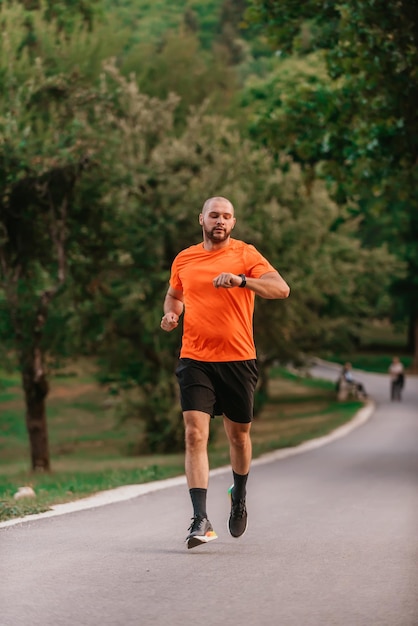 Athlete using a smartwatch while running in nature Healthy lifestyle