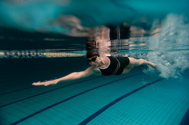 Athlete with goggles swimming full shot