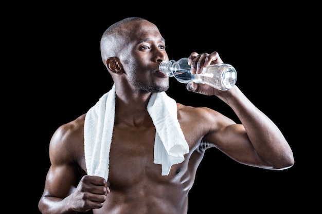 Athlete with towel around neck drinking water