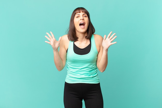 Athlete woman feeling happy, excited, surprised or shocked, smiling and astonished at something unbelievable