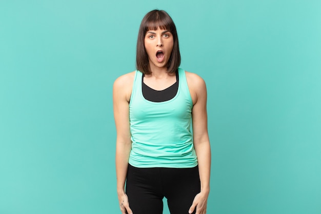 Athlete woman looking very shocked or surprised, staring with open mouth saying wow