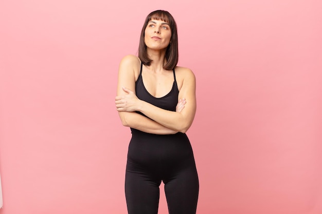 Athlete woman shrugging feeling confused and uncertain doubting with arms crossed and puzzled look