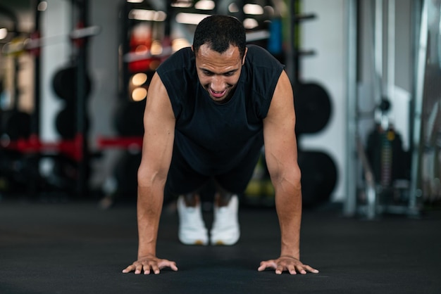 Athletic Black Man Making Floor Push Up Exercise While Training In Gym