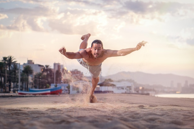 Athletic Caucasian male working out on the beach in the early morning - healthy lifestyle concept