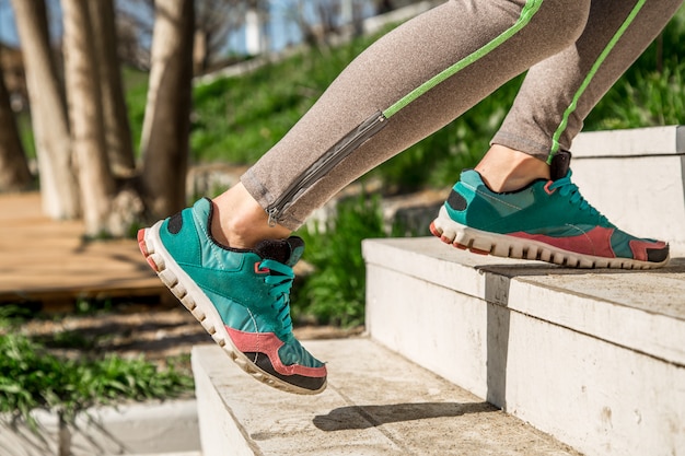 Athletic female legs climb the stairs