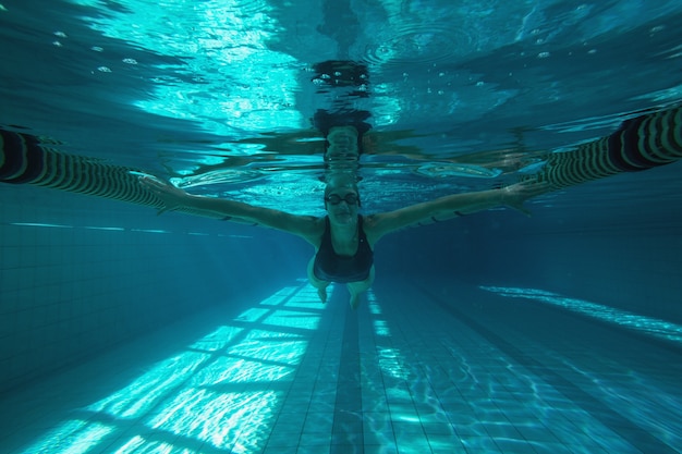 Athletic swimmer swimming towards camera