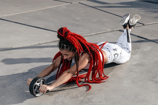 Athletic woman doing exercise exercise with a roller Strength and motivationPhoto of sporty woman in fashionable sportswear