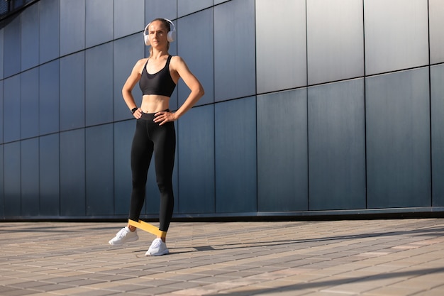 Athletic woman doing fitness exercise using fitness gum.