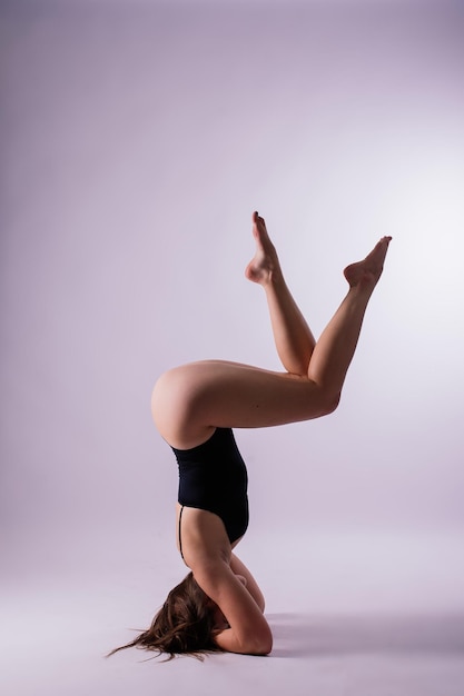 Athletic woman in swimsuit doing yoga pushups beautiful female exercising at studio