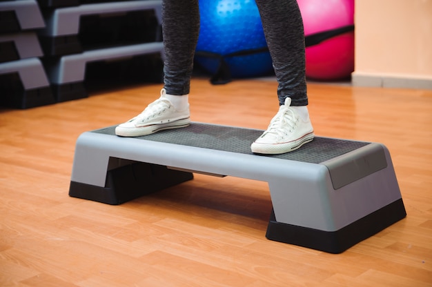 Photo athletic woman trainer doing aerobic class with steppers. sport