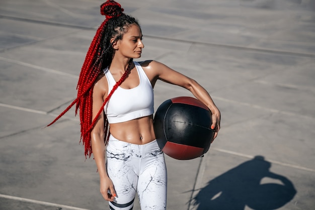 Athletic woman with med ball. Strength and motivation.Photo of sporty  woman in fashionable sportswear