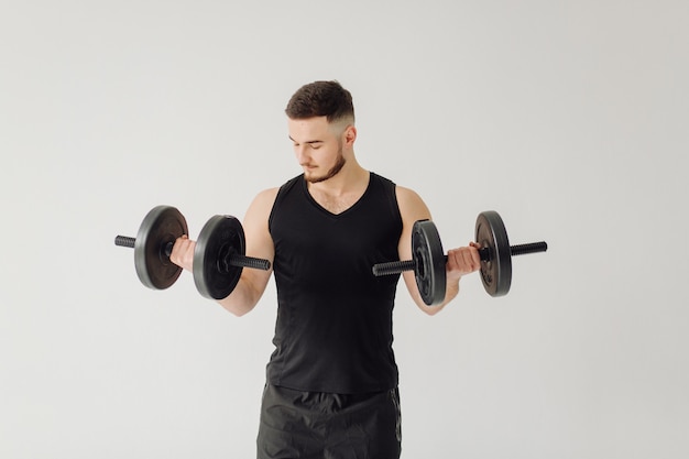 Athletic young man doing workouts at home, man doing training, warm up before weight exercise.