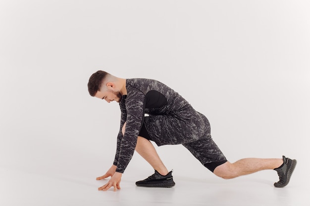 Athletic young man doing workouts at home, man doing training, warm up before weight exercise.