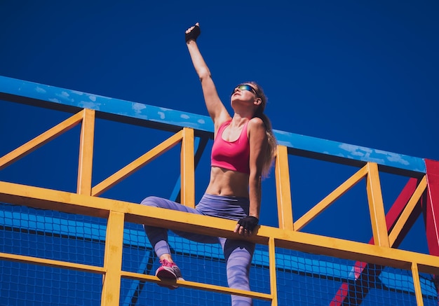 Athletic young woman working out and climbing at the training camp