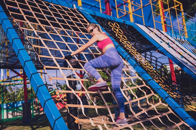 Athletic young woman working out and climbing at the training camp