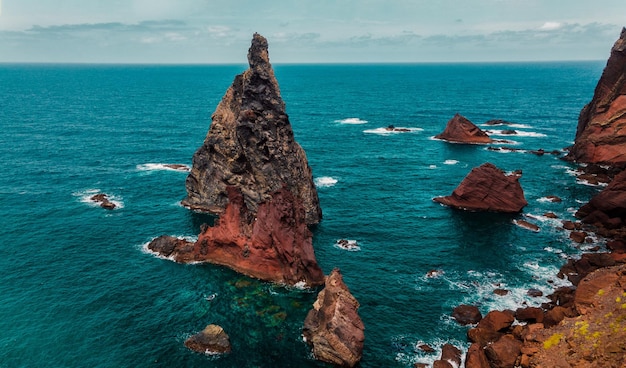 Atlantic ocean coast red cliff waves sea foam Madeira island Portugal aerial drone photography