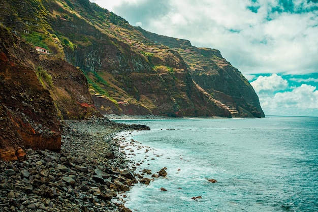 Atlantic ocean coastline with cliffs rocks waves sea foam Madeira island Portugal