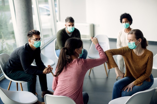 Attenders of group therapy greeting with elbows due to COVID19 pandemic