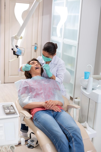 Attentive female doctor examining a young patients mouth