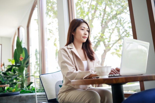 Attractive Asian businesswoman working by laptop in the coffee shop Confident and smart woman and business concept