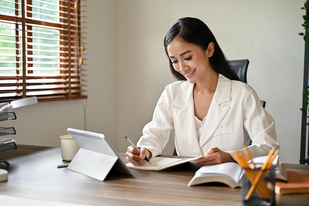 An attractive Asian businesswoman working on her business tasks at her desk