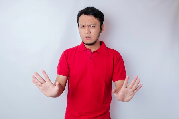 Attractive Asian man with hand gesture pose rejection or prohibition with copy space