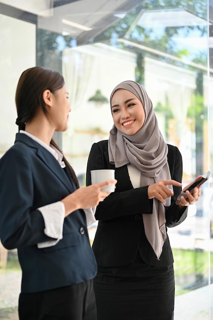 Attractive Asian Muslim businesswoman enjoy chatting and sharing ideas with her colleague