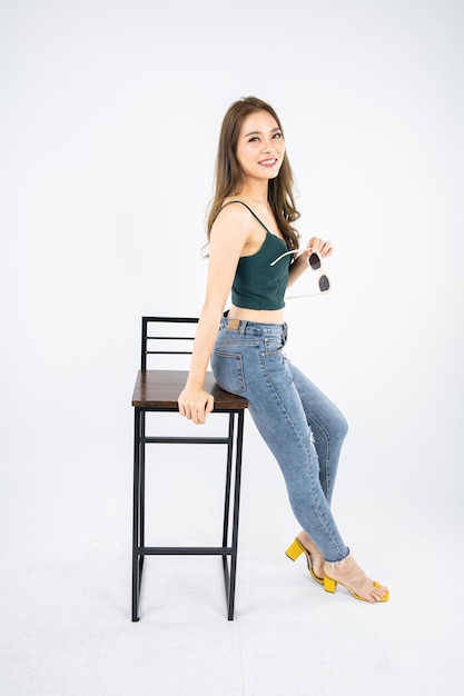 Attractive asian young woman sitting in bar chair on white background