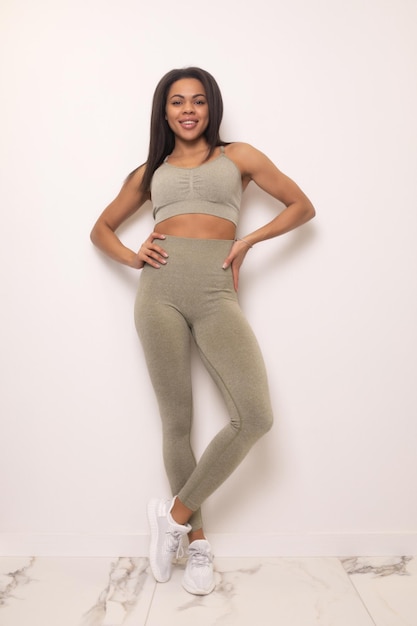 Attractive black african american woman in leggings and top fitness outfit