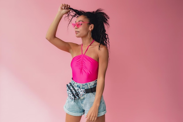 Attractive black african american woman in stylish outfit on pink background