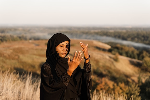 Attractive black woman praying to Allah on his prayer in Ramadan month.