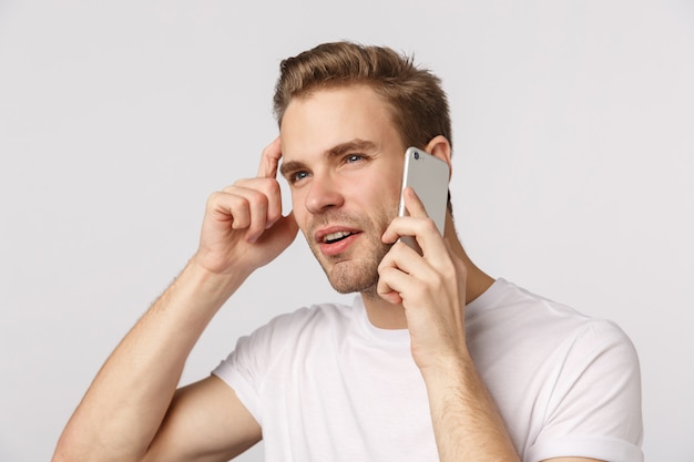 Attractive blond bearded man in white T-shirt calling