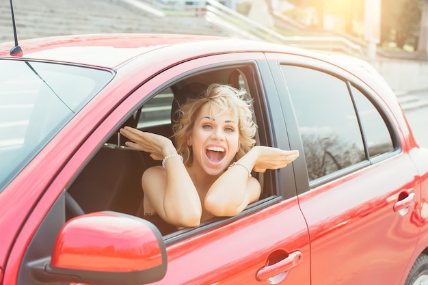 Attractive blonde in a car showing keys