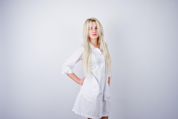 Attractive blonde female doctor or nurse in lab coat isolated on white background