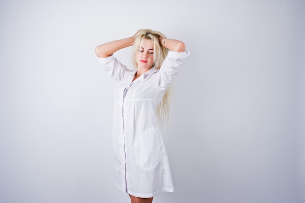 Attractive blonde female doctor or nurse in lab coat isolated on white background