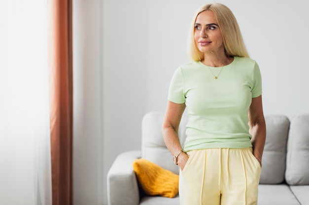 Attractive blonde middle-aged woman in living room at home